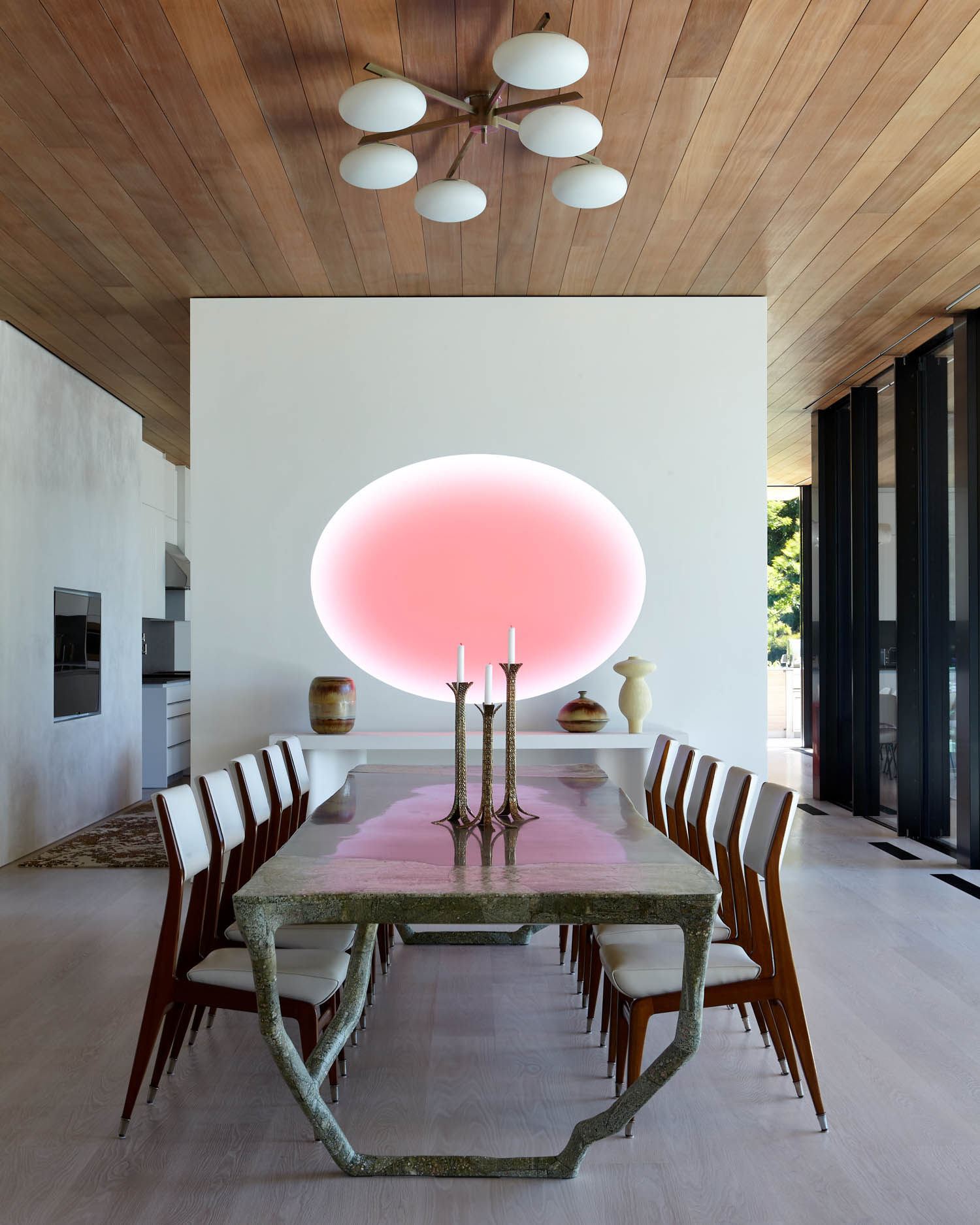 dining area with long table and bright pink light
