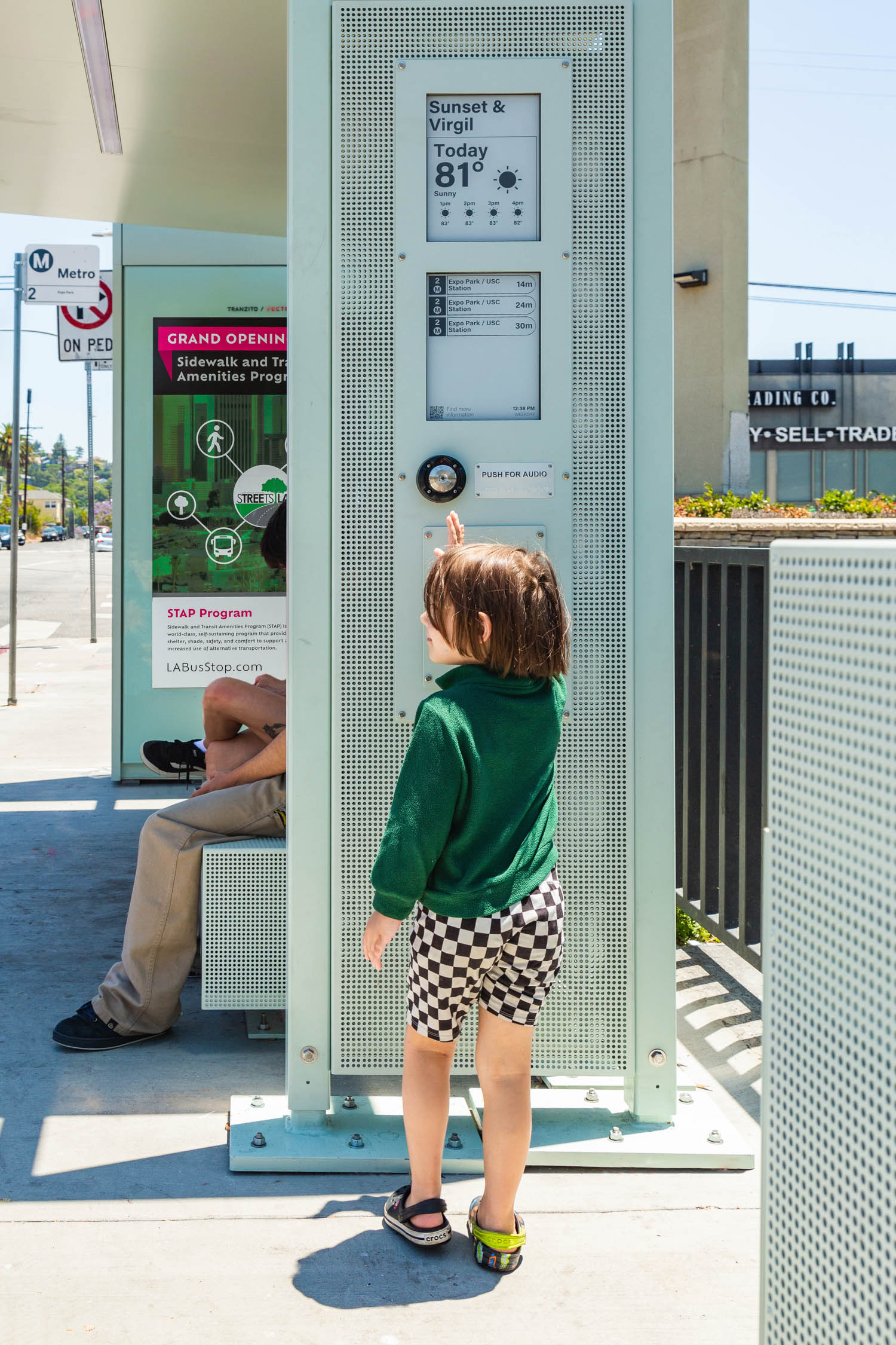 child standing next to bus shelter