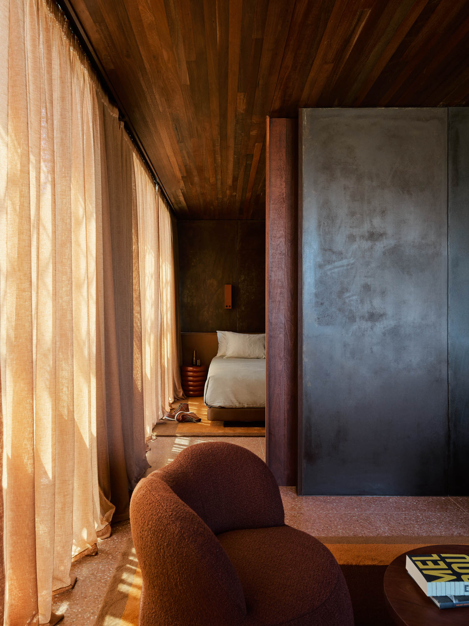 room with tan chairs and drapes covering windows