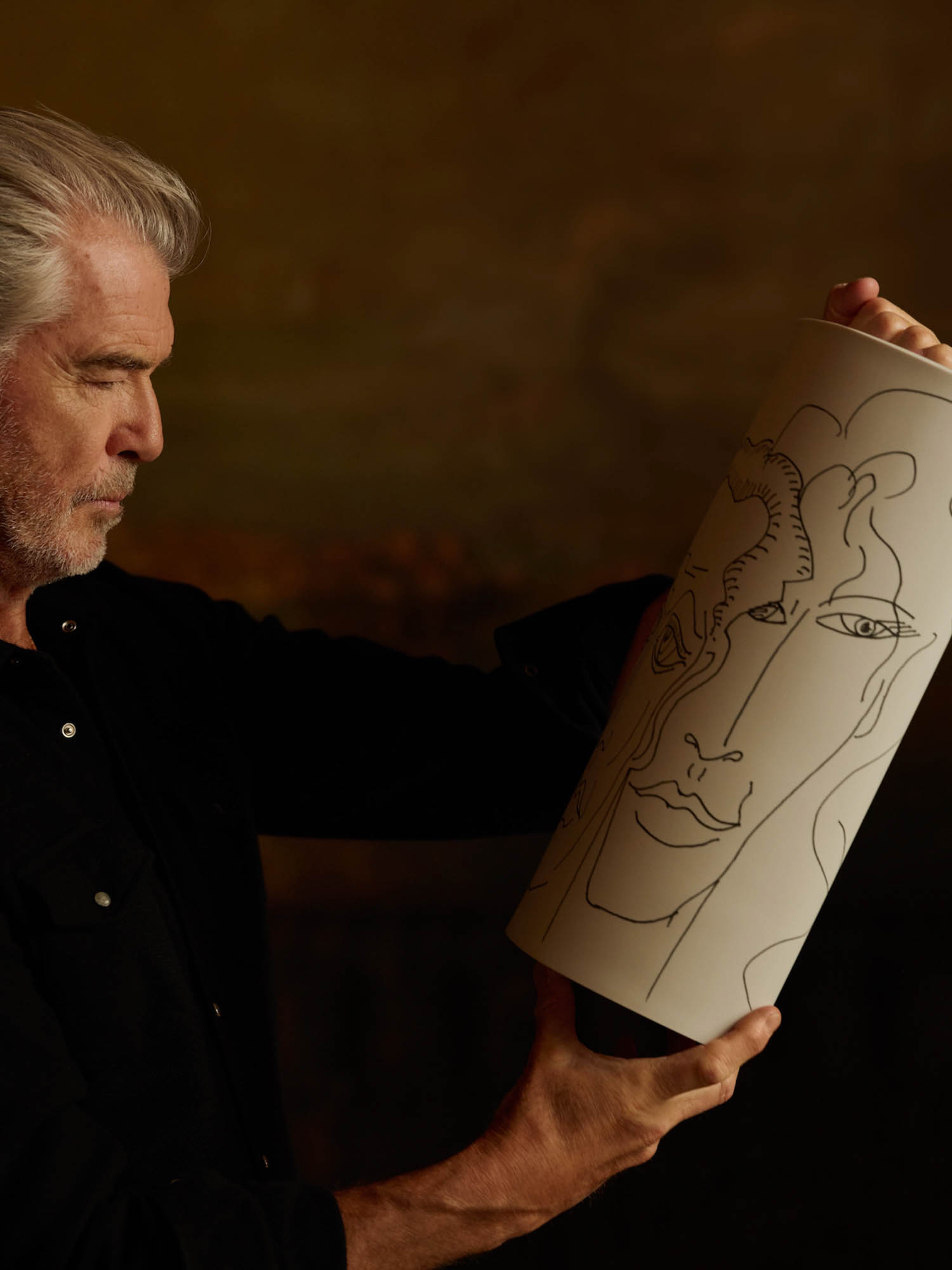 Pierce Brosnan holding up vases