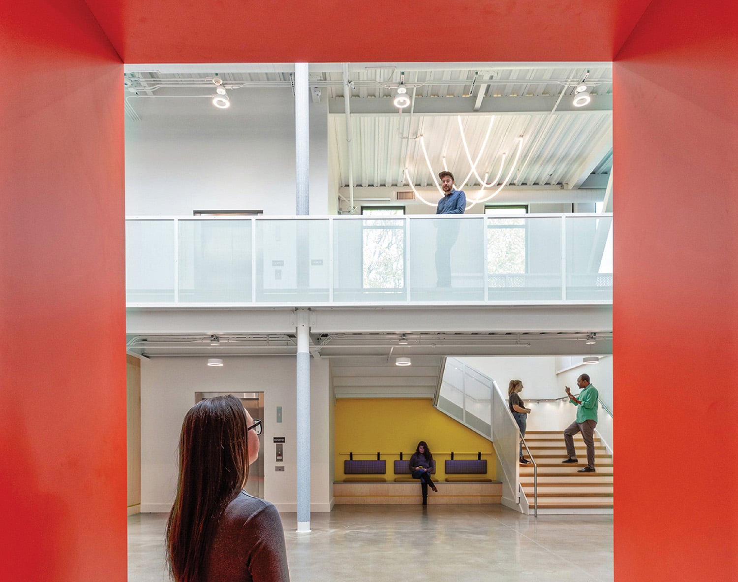 A woman standing in a room with a red wall