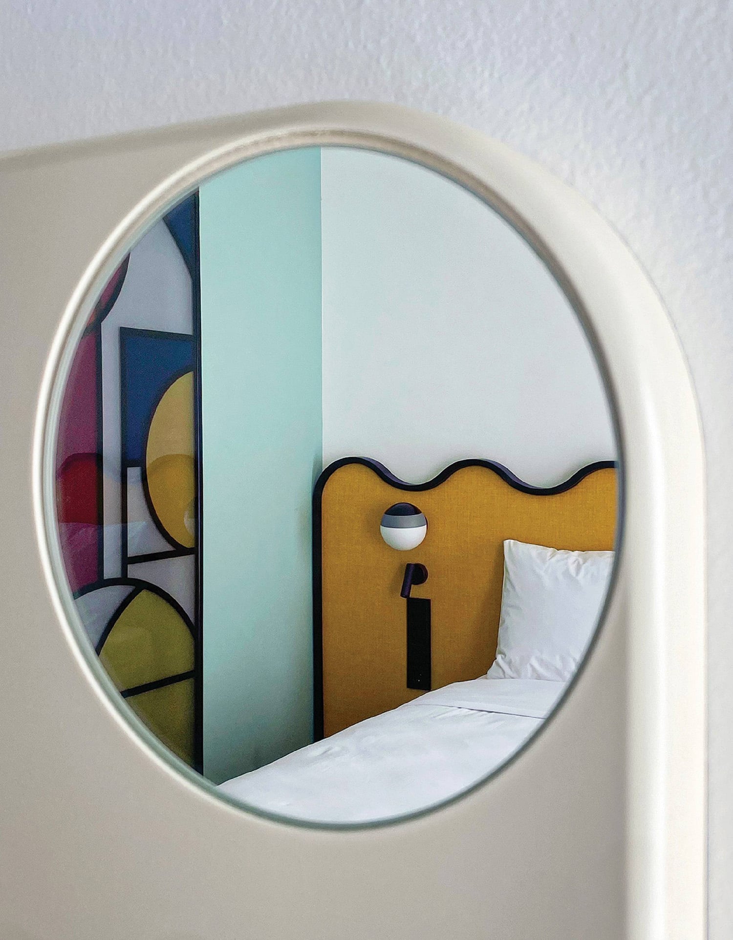 A mirror that is reflecting a bed