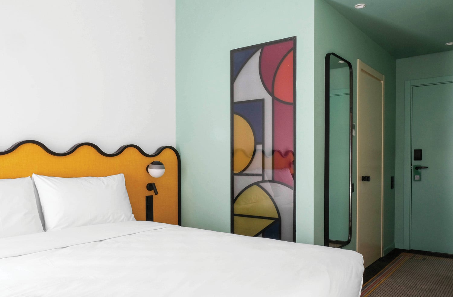 A bed with white sheets and a yellow headboard