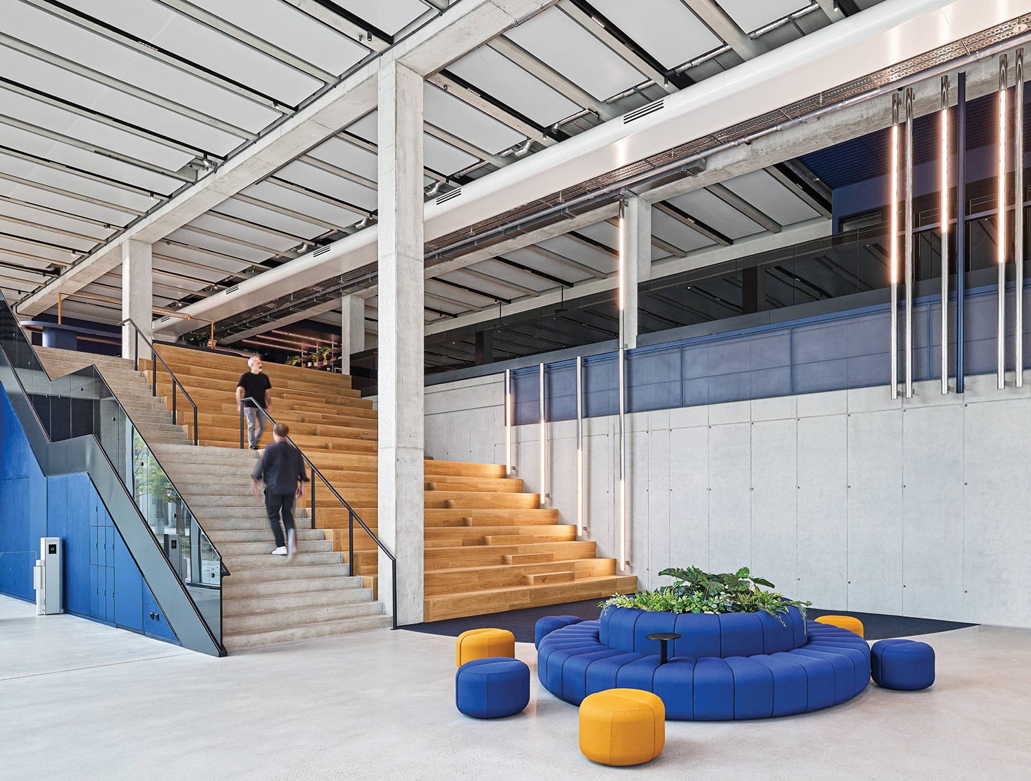 A large room with a staircase and a blue couch