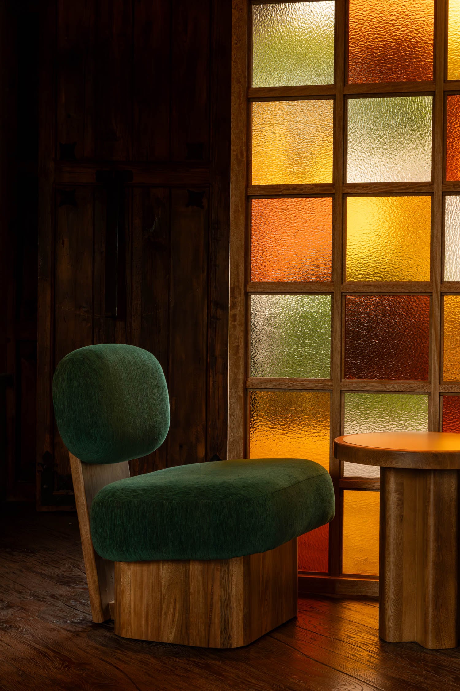 green velvet chair in room with stained glass