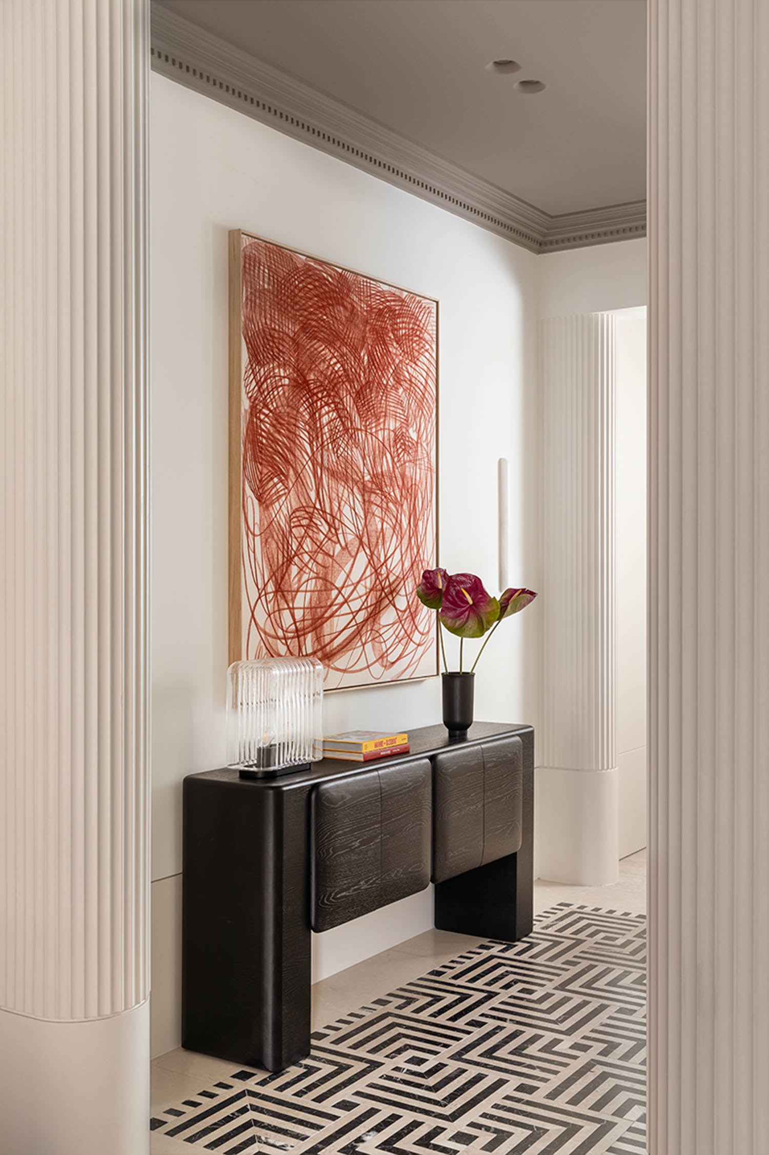 entryway with black console table and red art