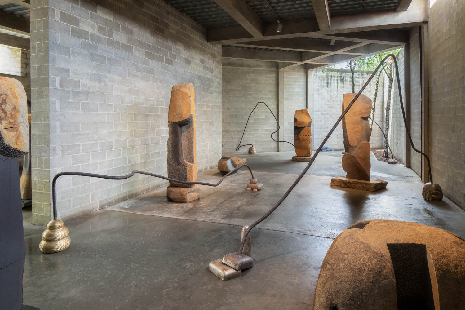room with multiple stone sculptures by Temitayo Ogunbiyi