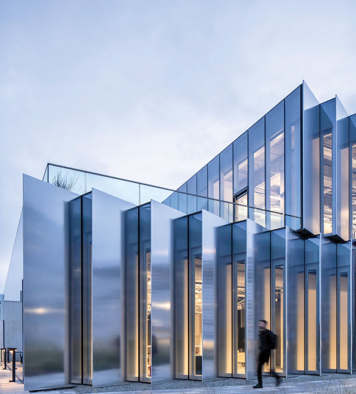 A building with glass walls and a person walking in front