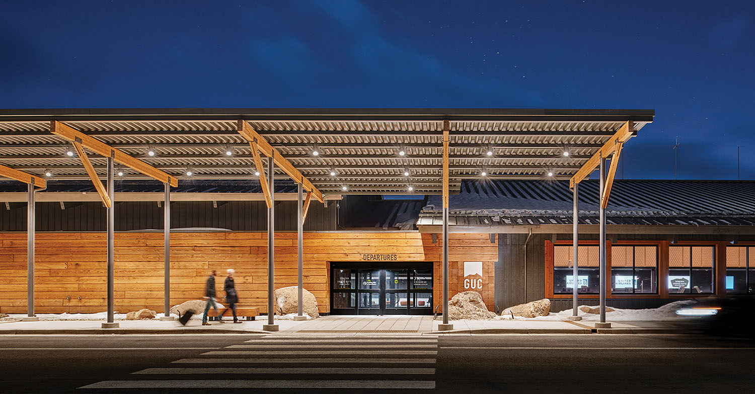 A building with a wooden roof and a man walking across the stree