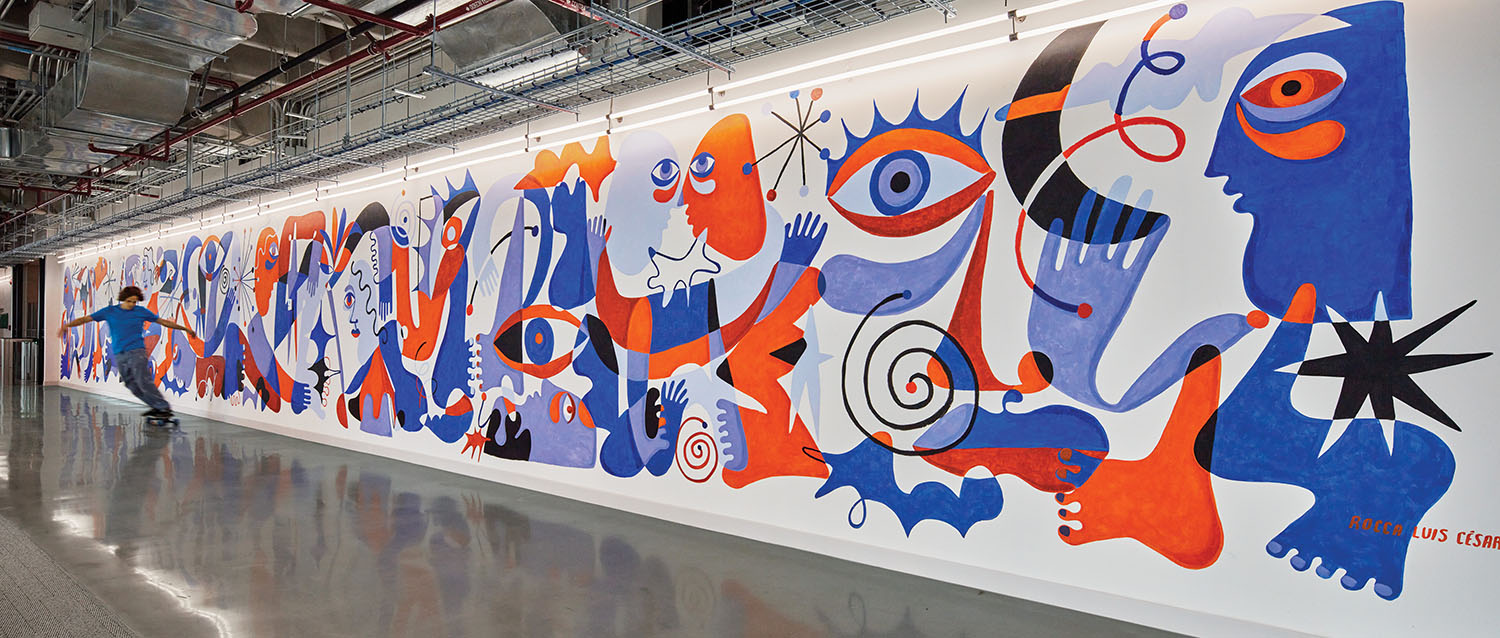 A large wall with many colorful paintings on it