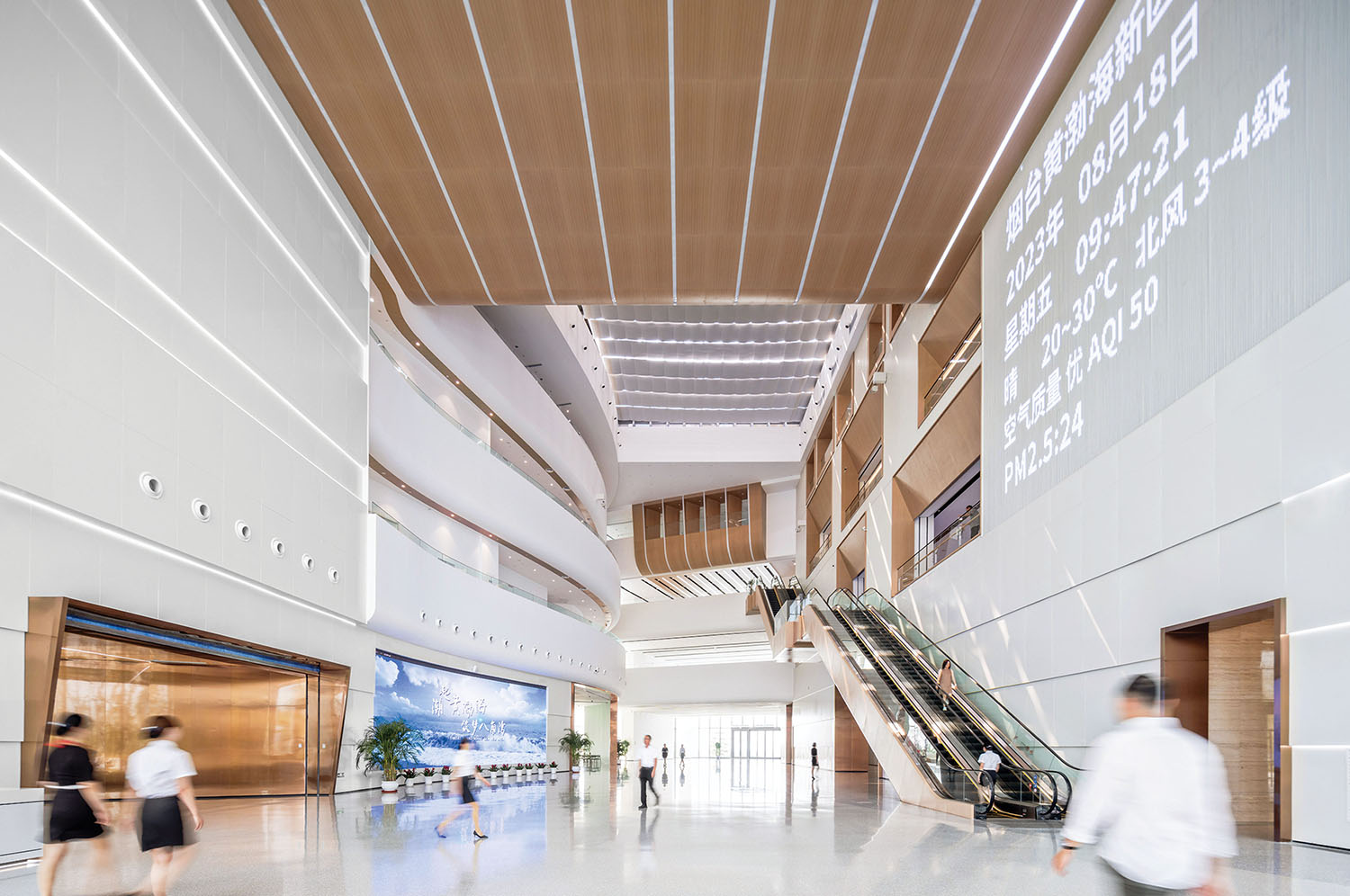 A large lobby with a staircase and a large screen