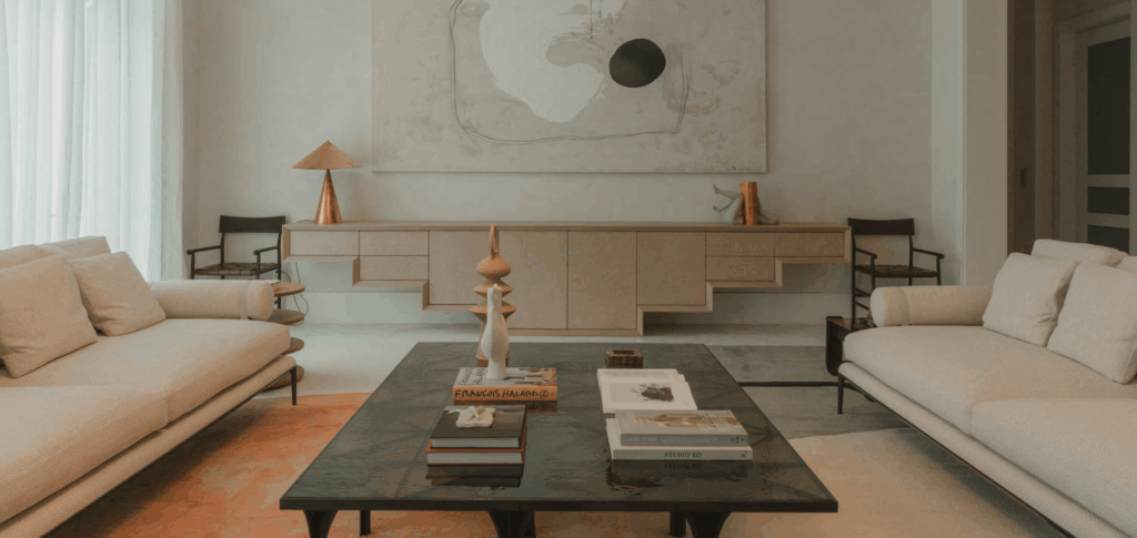living room with white couches and black coffee table with books