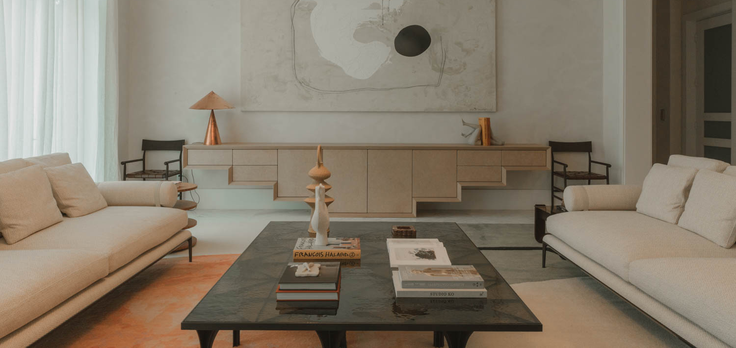 living room with white couches and black coffee table with books