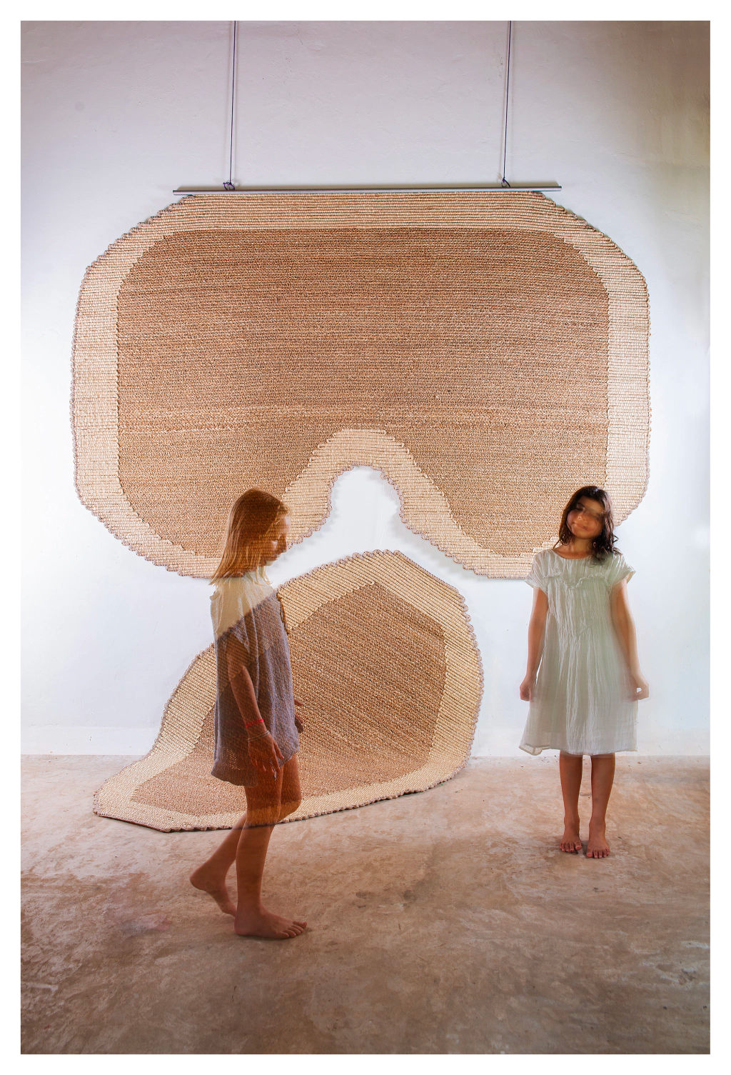 two girls standing in a room with rugs