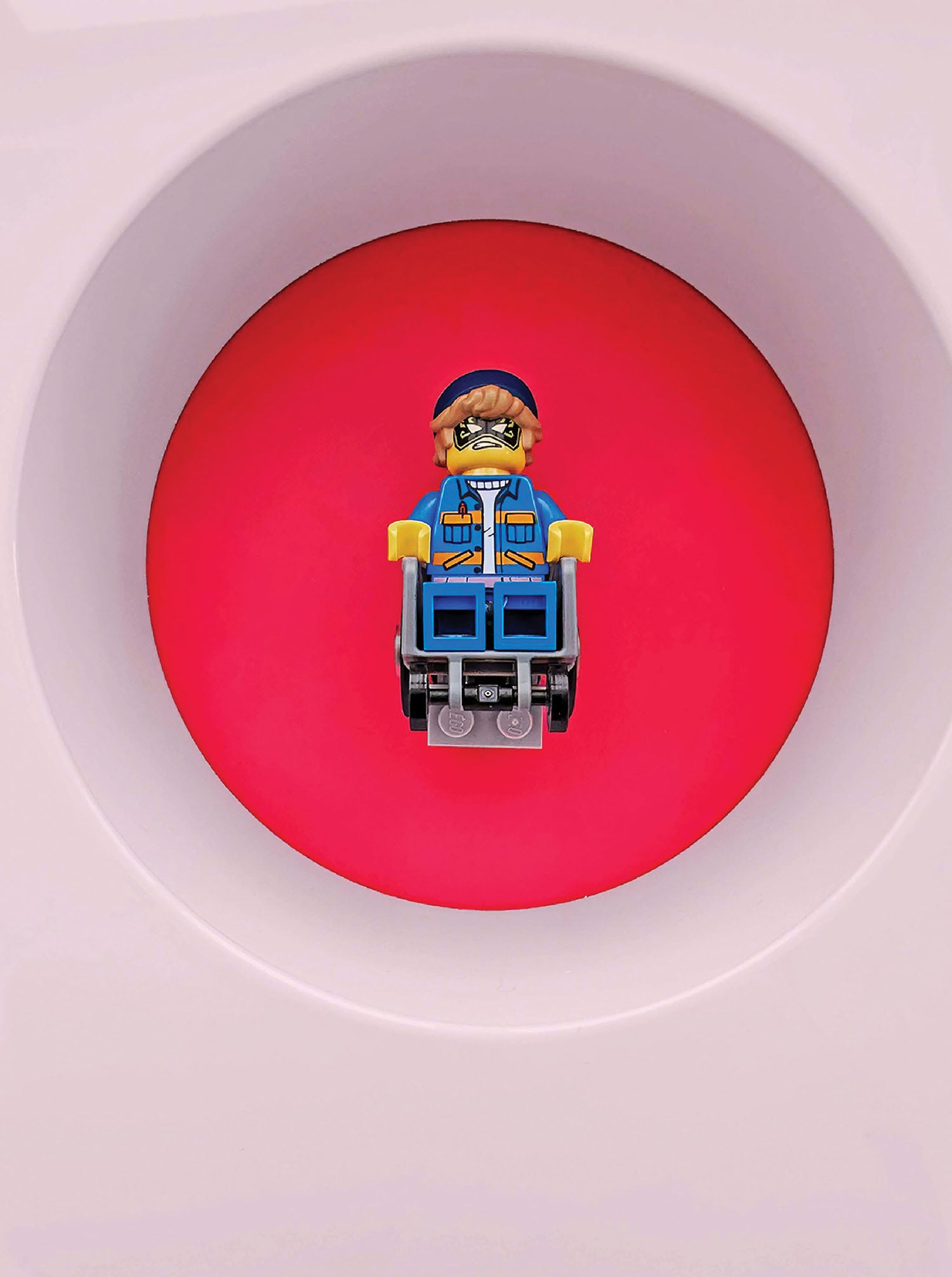 A lego man sitting on top of a toilet.