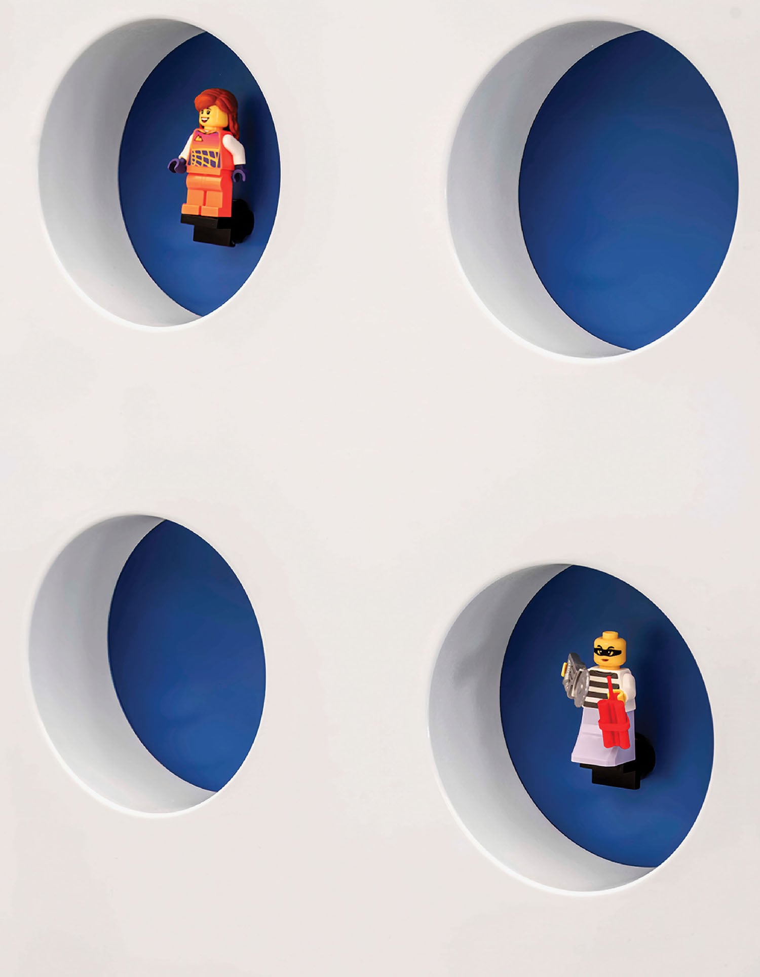 A white wall with four blue circles and a small figure.