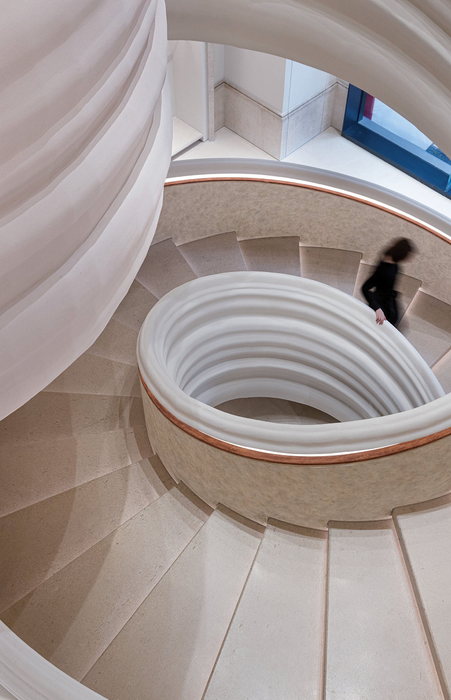 A person walking up a spiral staircase.
