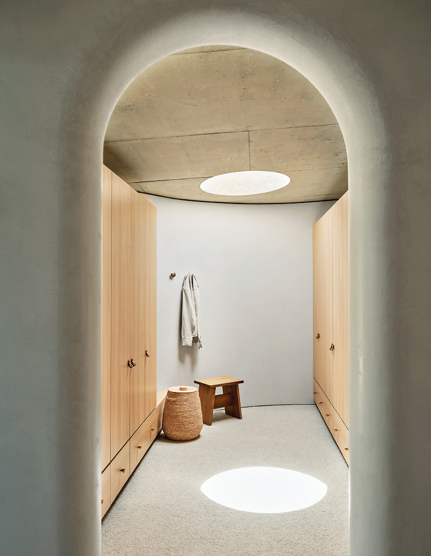 A hallway with a bench and a coat rack