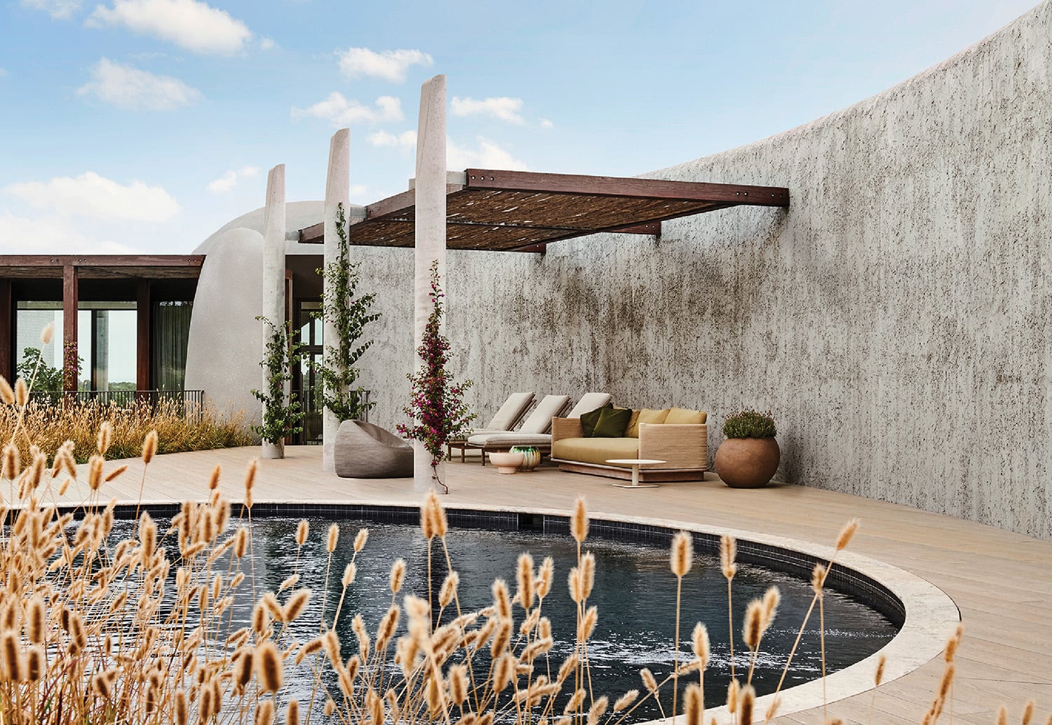 A pool with a wooden deck and a wooden bench