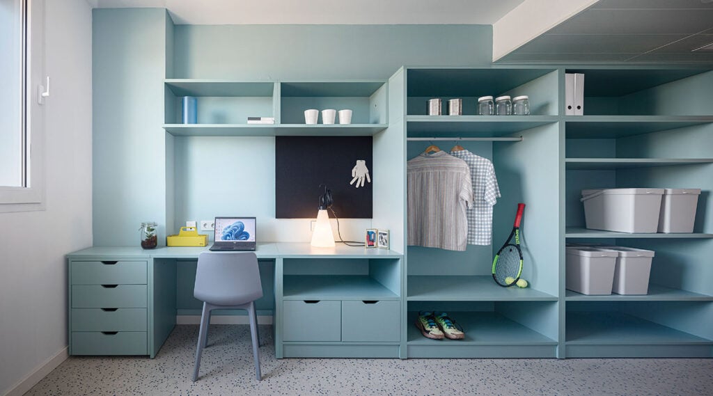 a room with a desk and a shelf