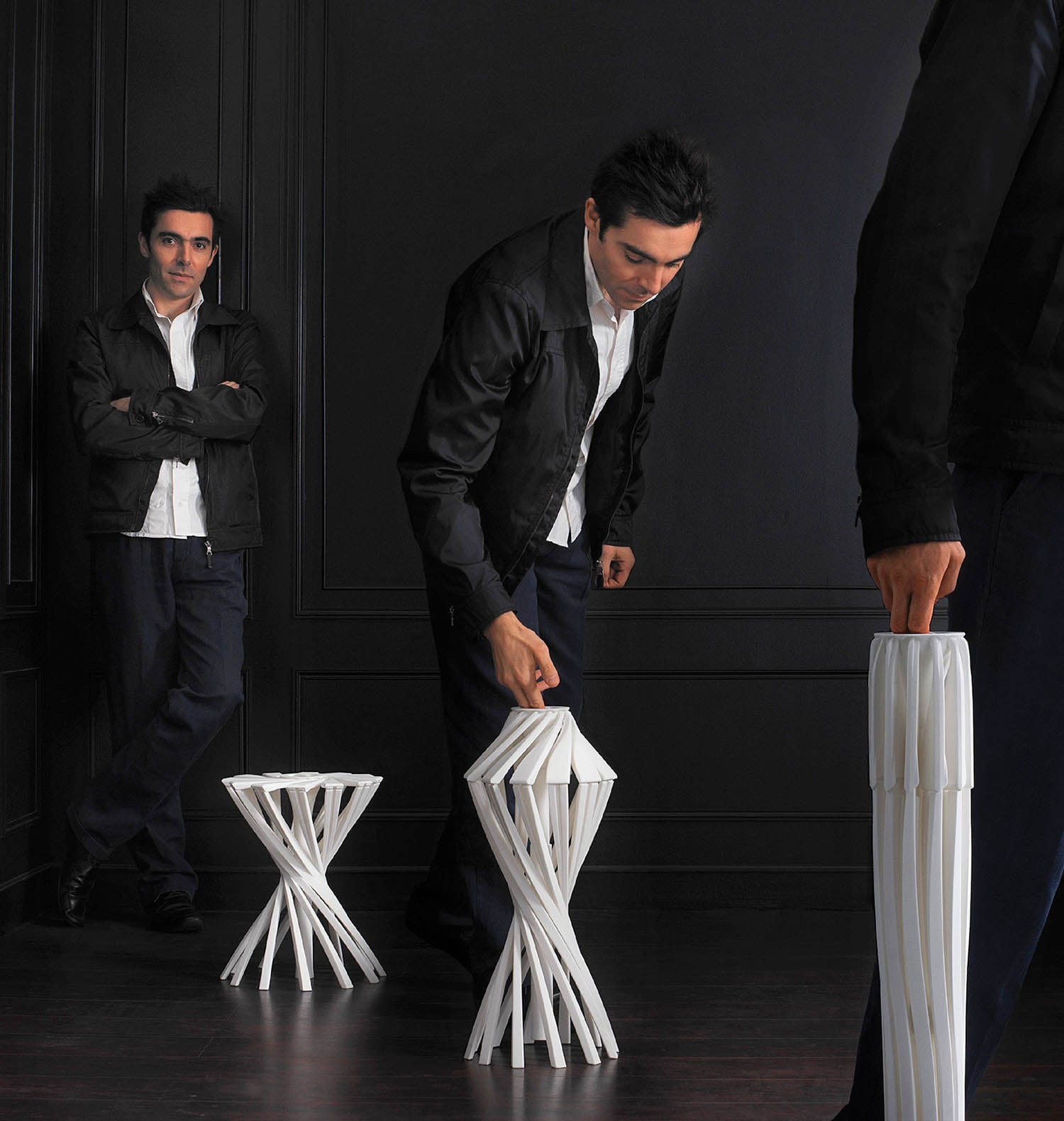 A man in a suit standing next to a white chair.