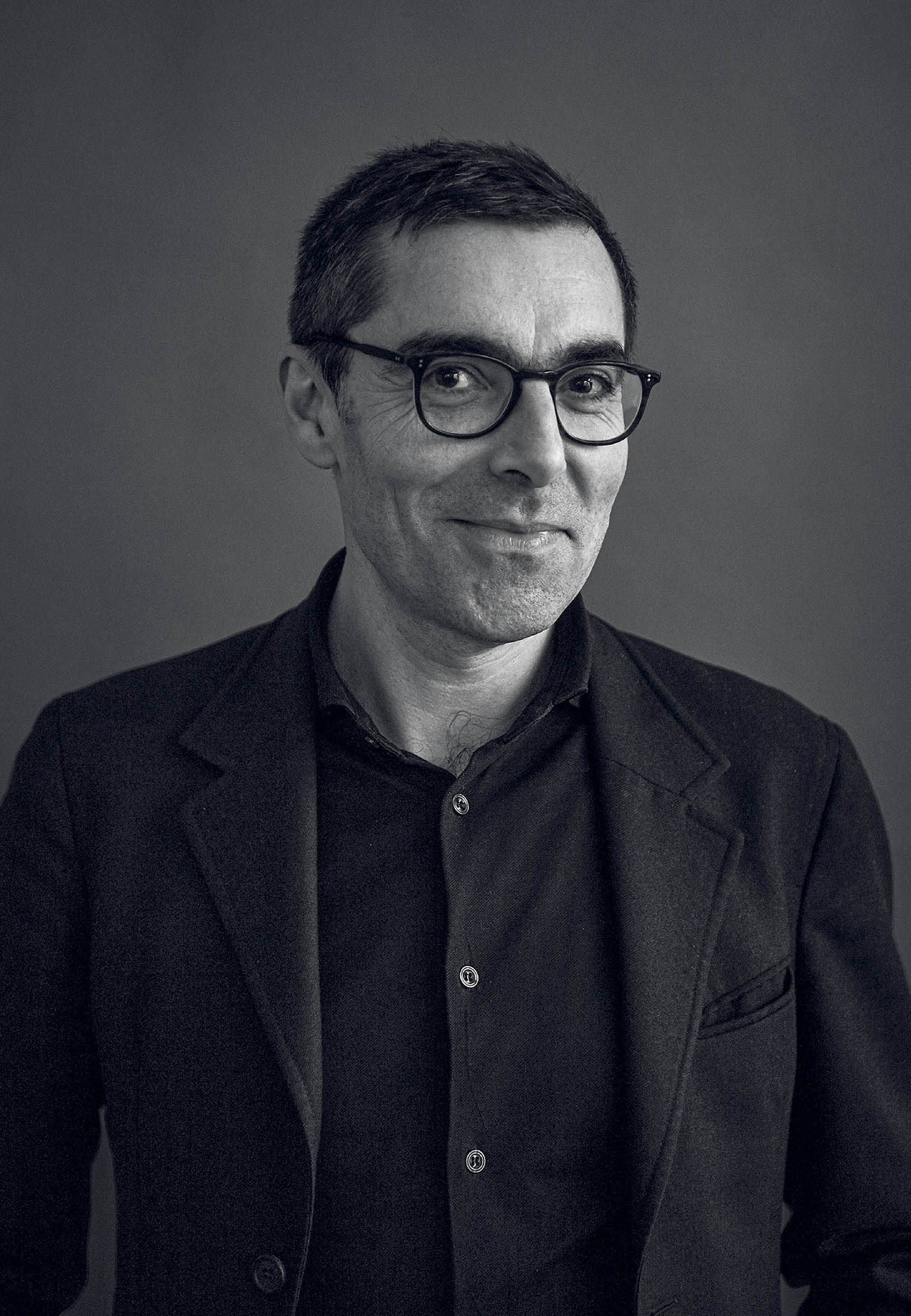 A man in a suit and glasses posing for a picture.