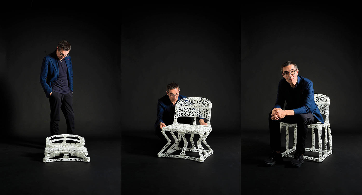 A man sitting on a chair with a black background.