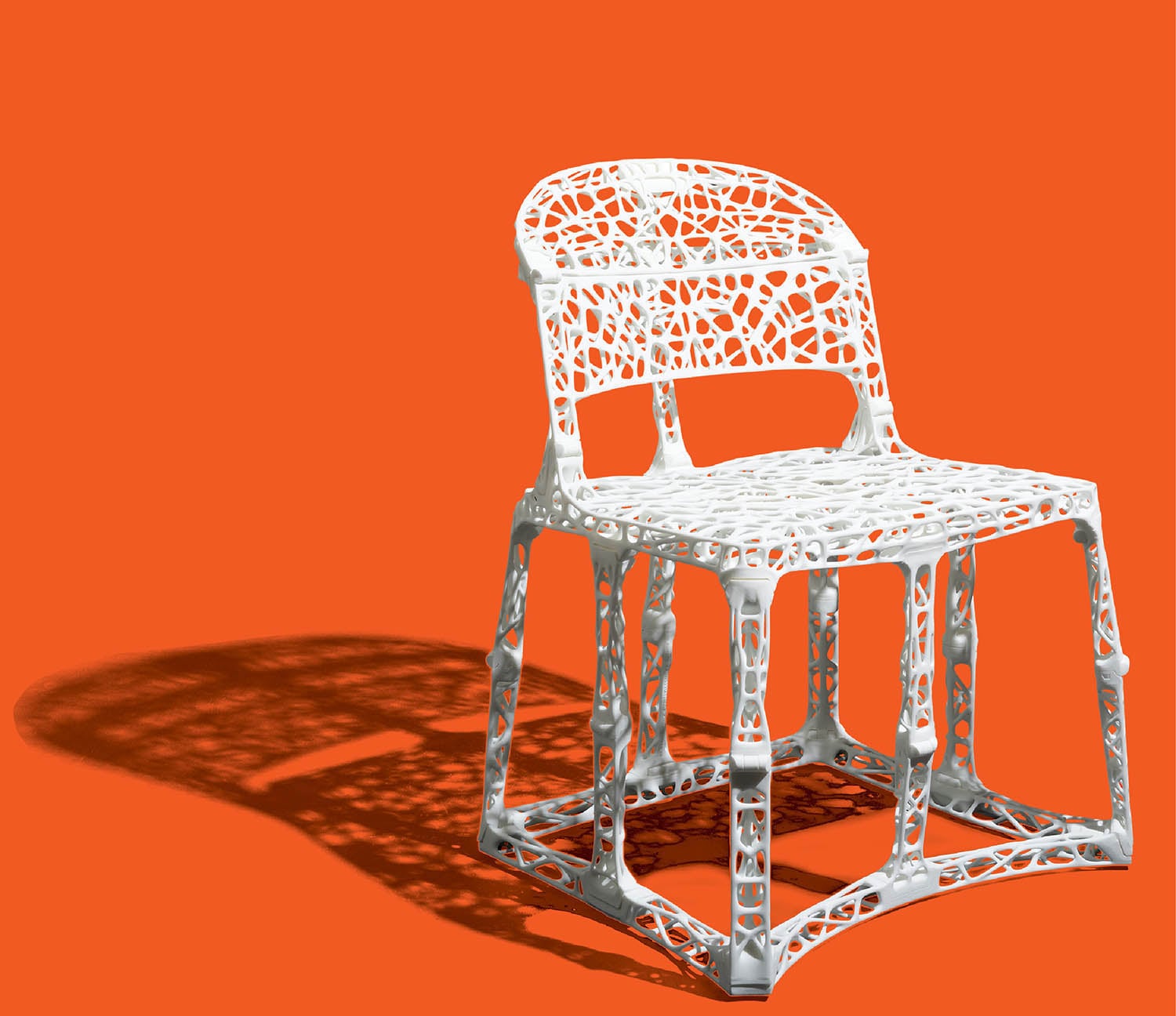 A chair made out of metal on a red background.