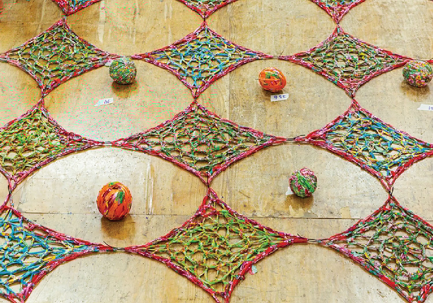 A colorfully colored crochel on a wall.