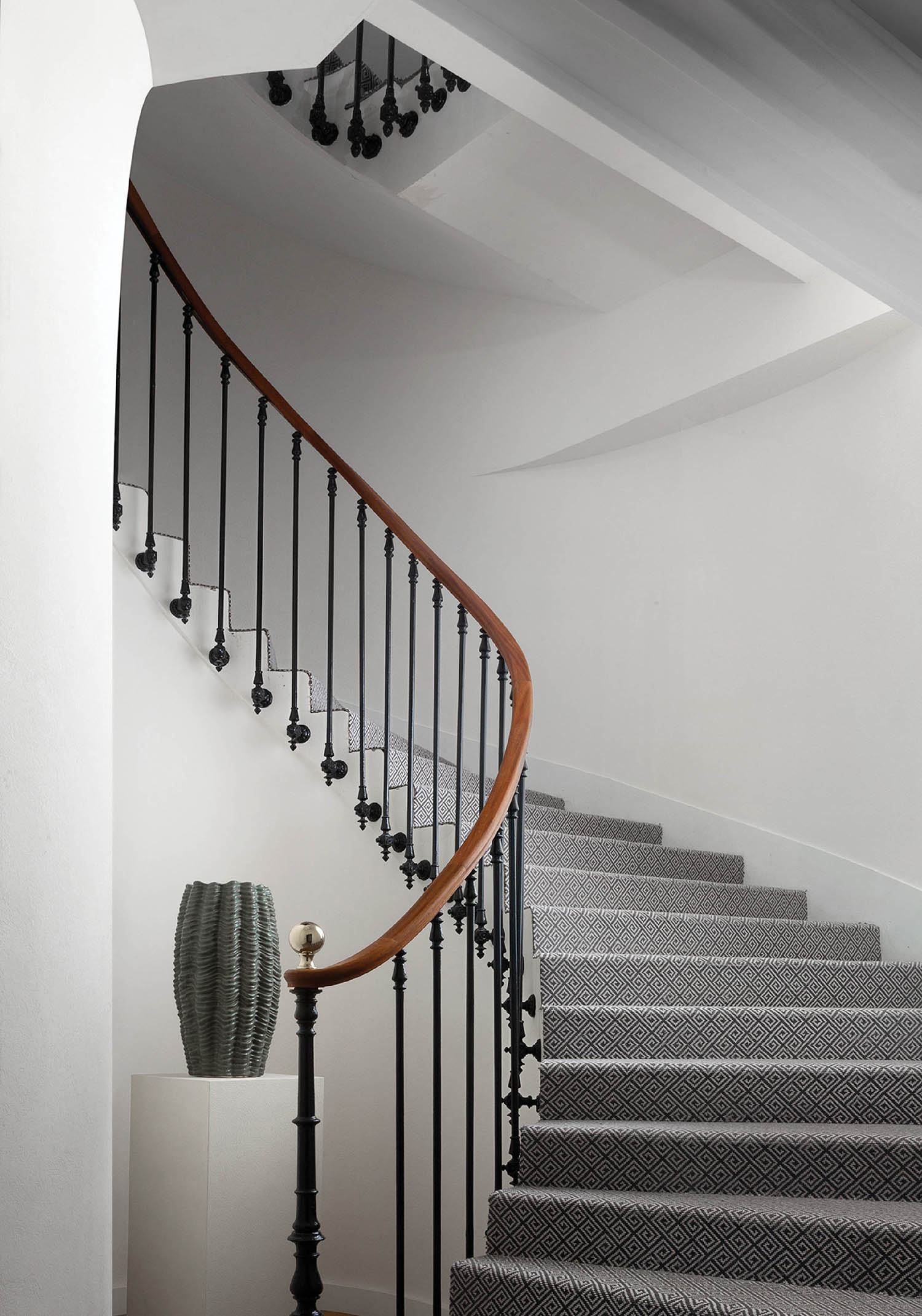 A staircase with a black and white patterned carpet.
