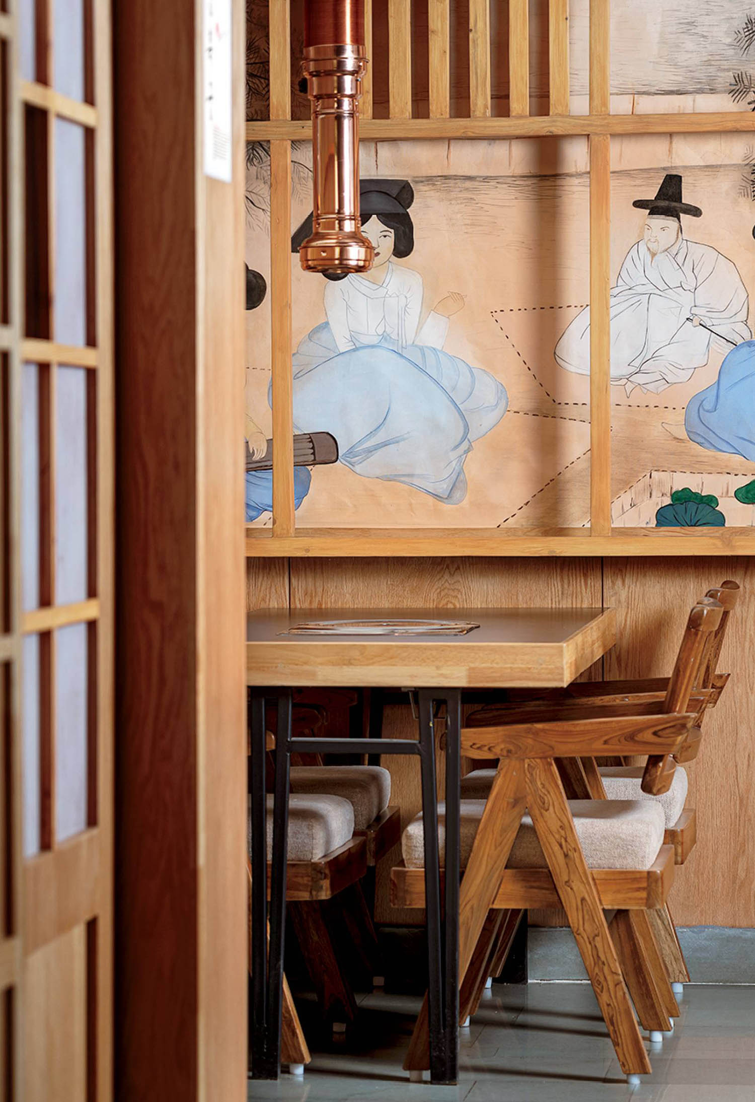 A wooden table with a chair and a painting on the wall.