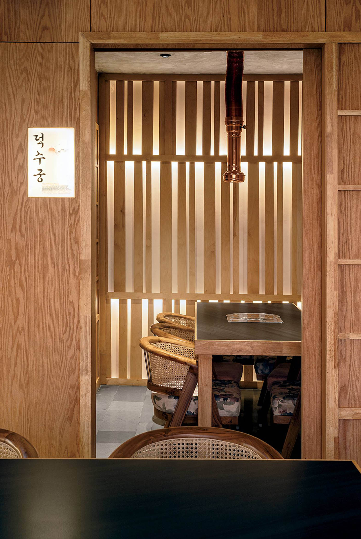A wooden wall with a wooden table and chairs.