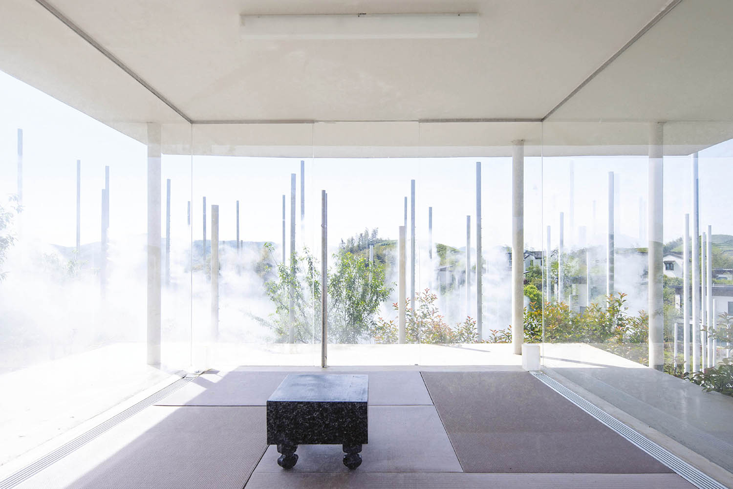 A room with a large window and a bench.