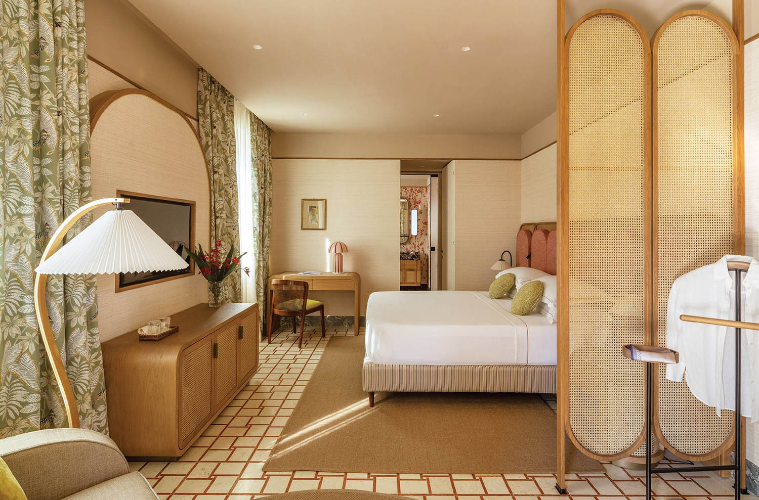 A hotel room with a bed, chair, and a television.