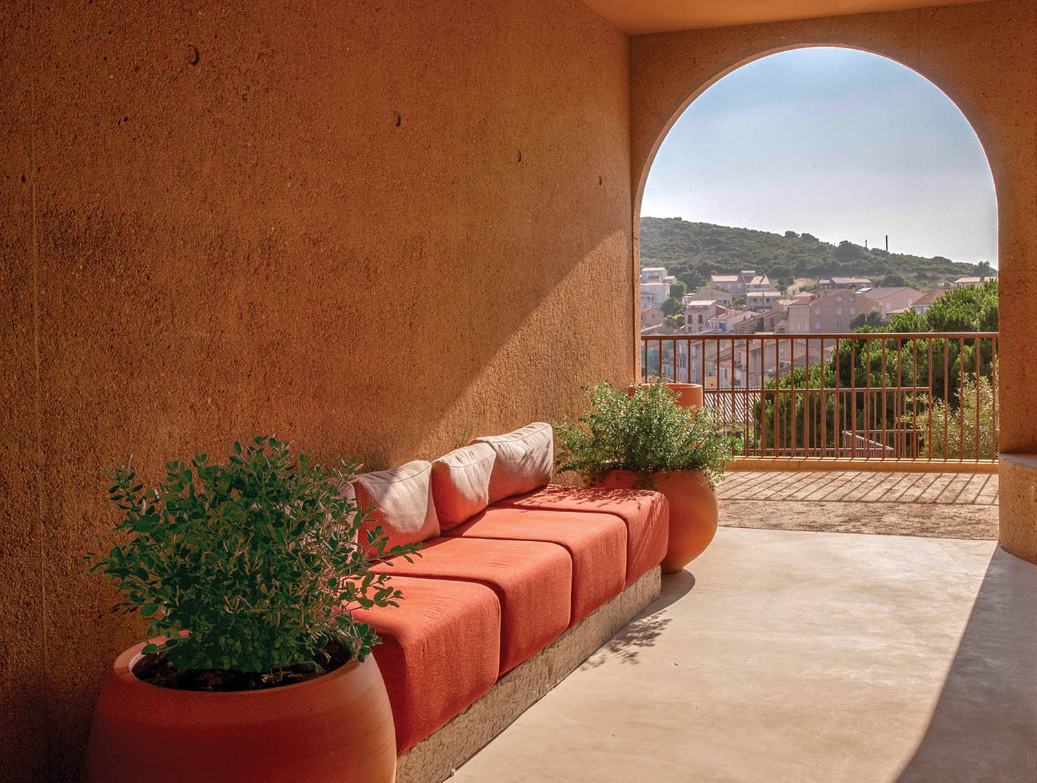 A balcony with a couch and a planter.
