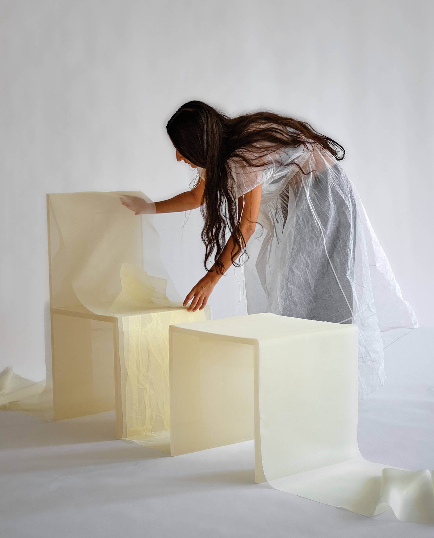 A woman is putting a piece of paper into a box.