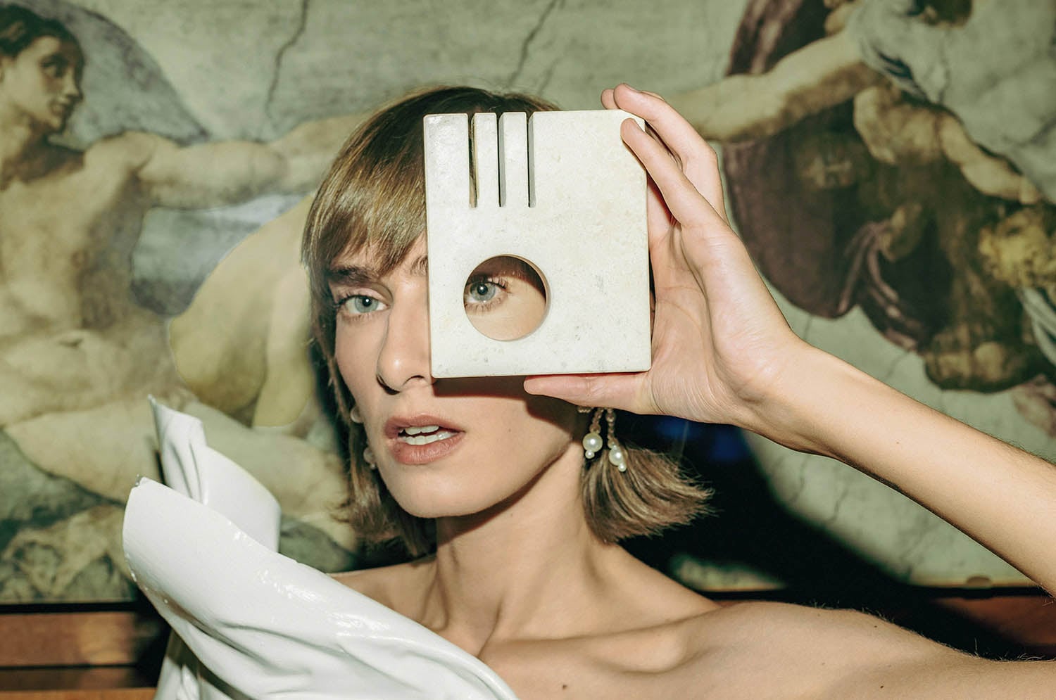 A woman holding a white object in front of her face.