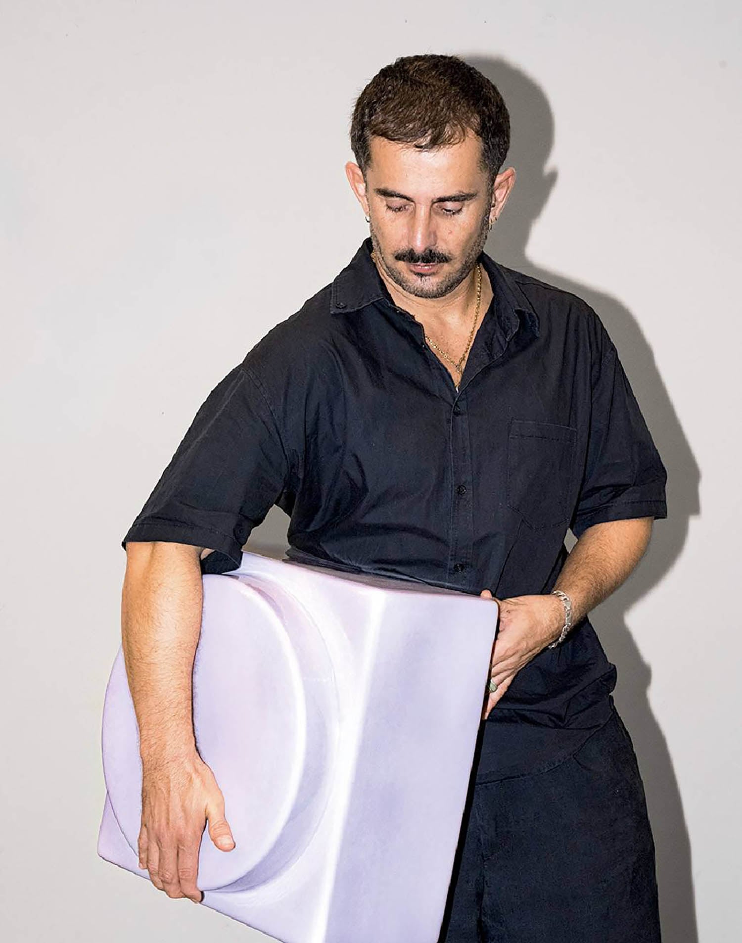 A man holding a purple box with a white lid.