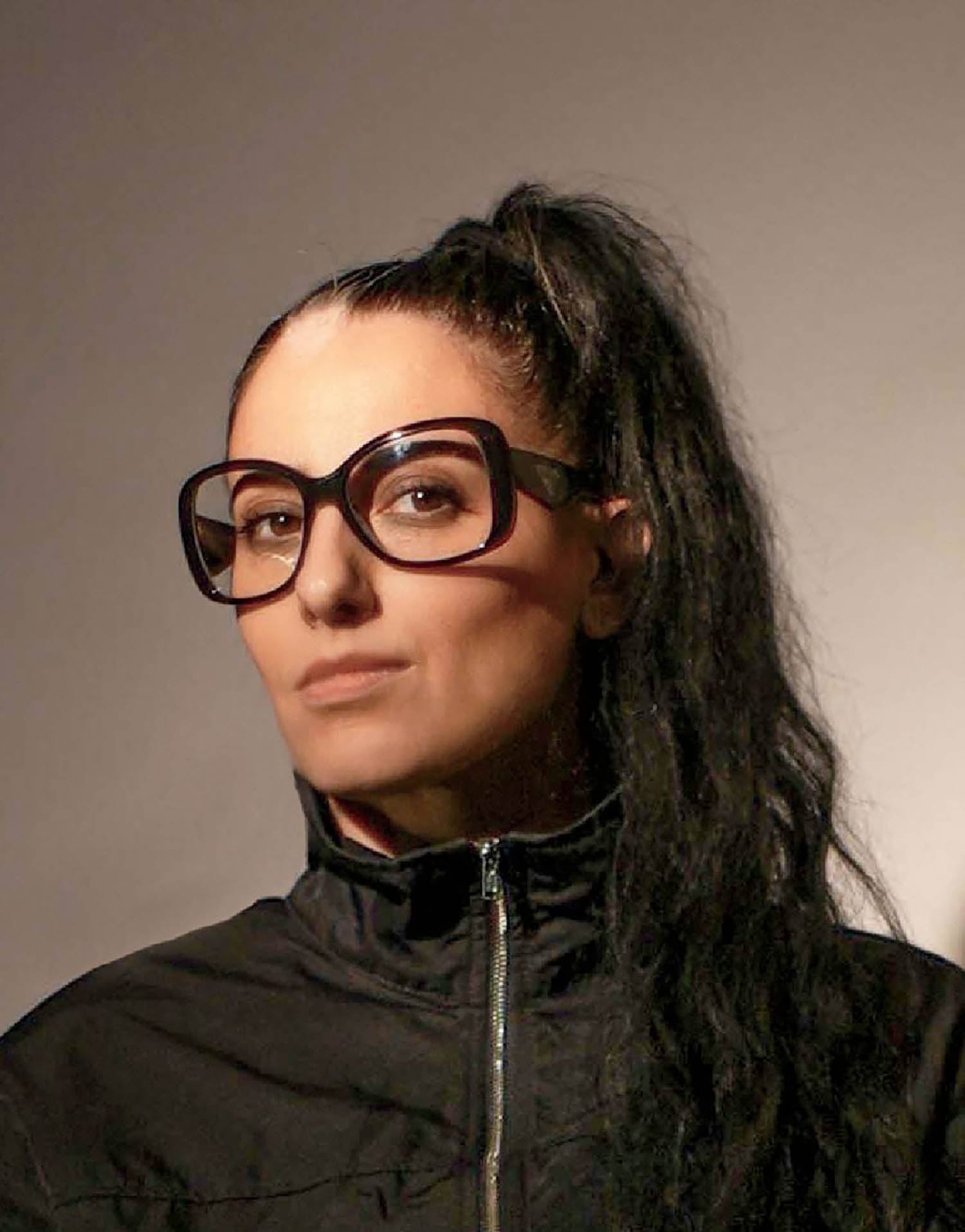 A woman with long black hair and glasses.