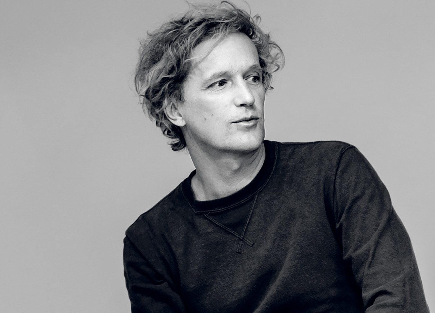 A man sitting on a chair with his hands on his knees