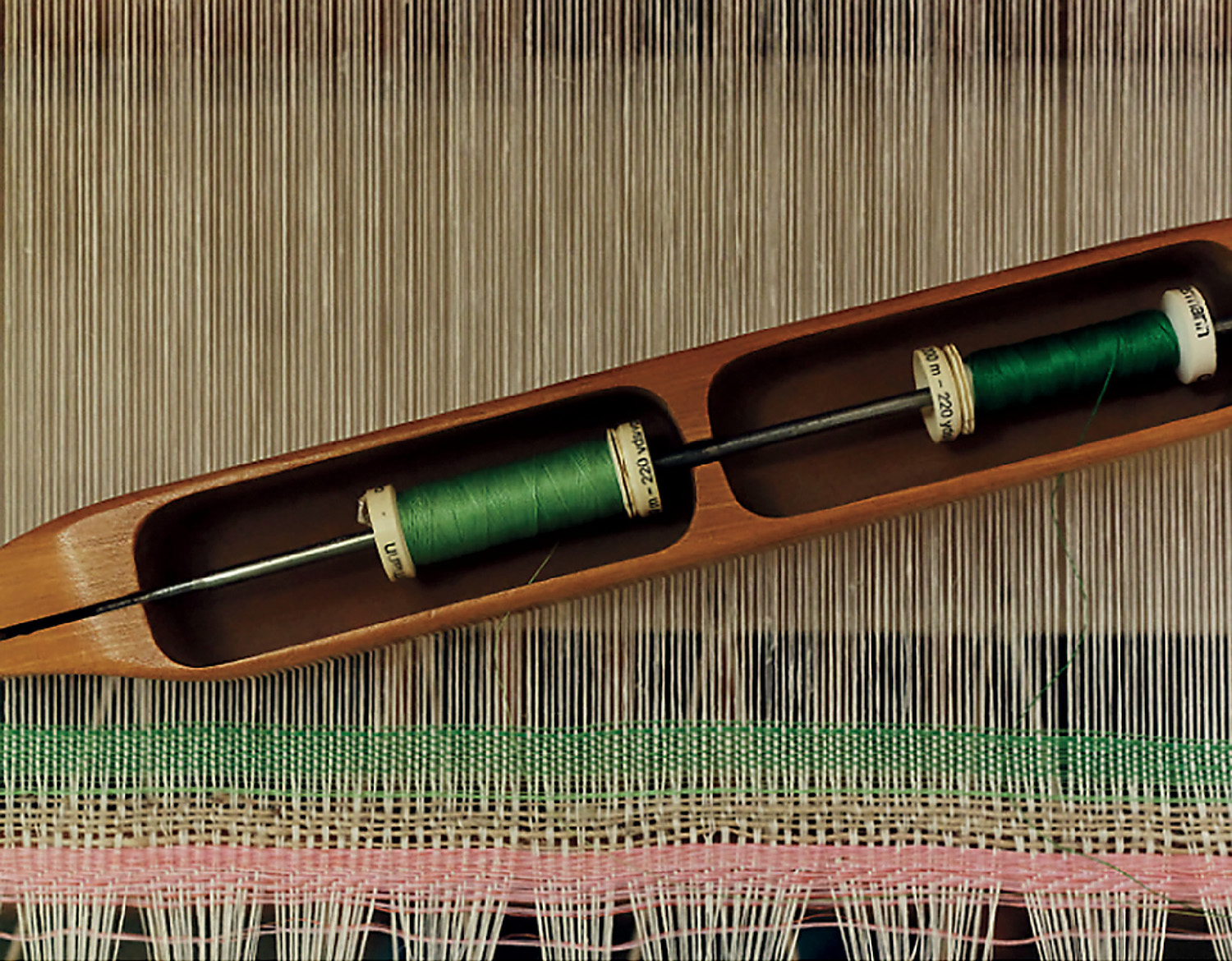 A wooden boat with a green and red yarn