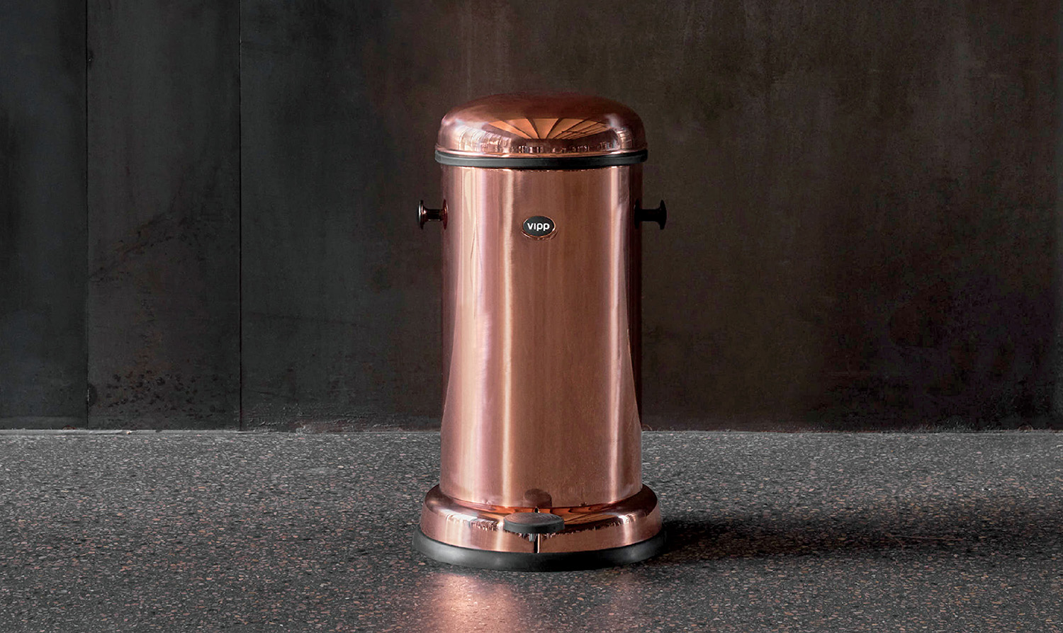 A copper colored trash can on a granite counter