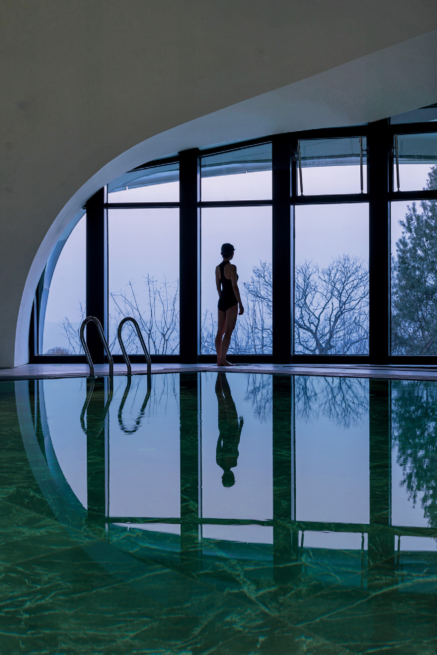 A woman in a pool looking out at the view