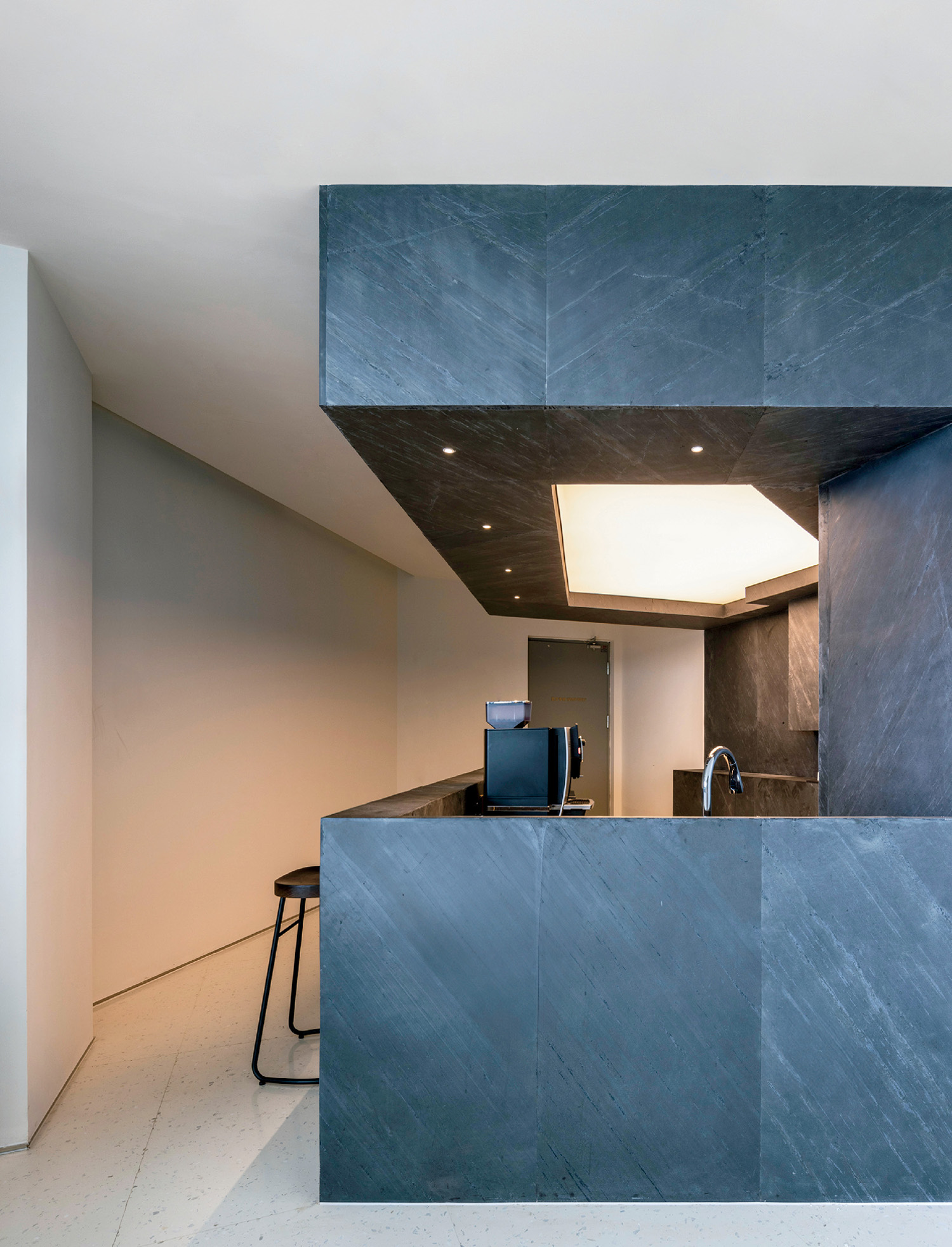 A kitchen with a blue counter and a white wall