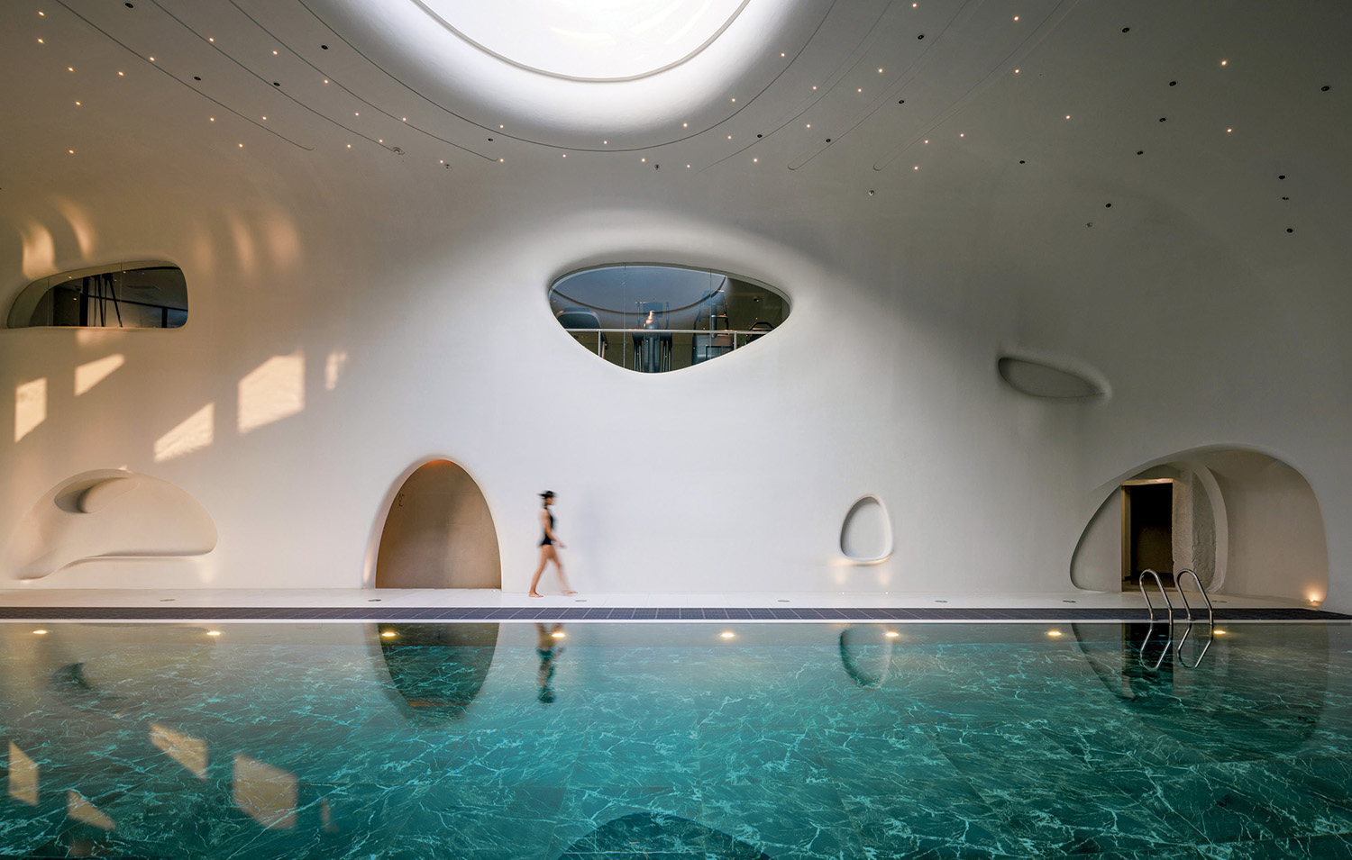 A woman standing in a pool with a mirror above her