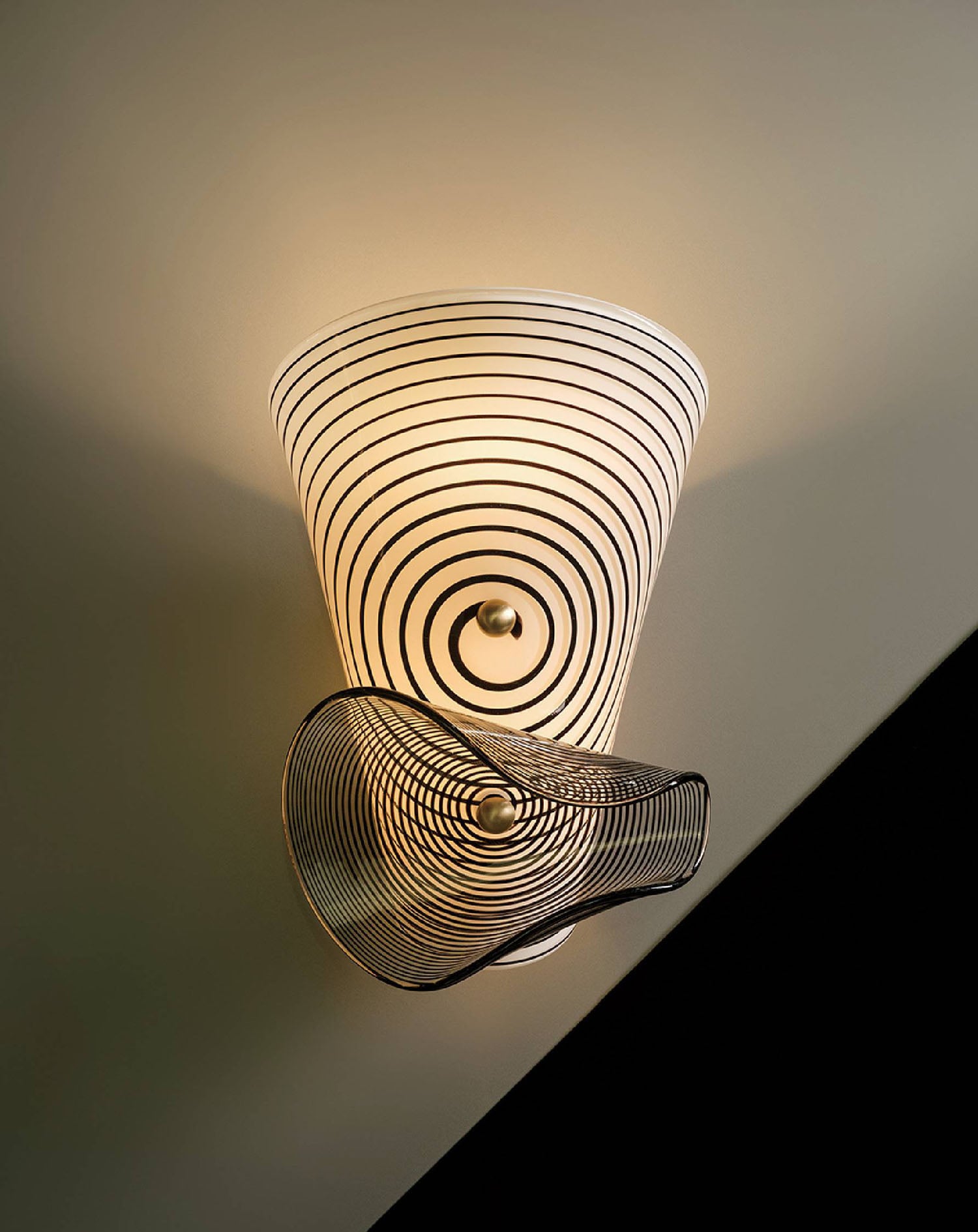 A wall light with a spiral design on it.