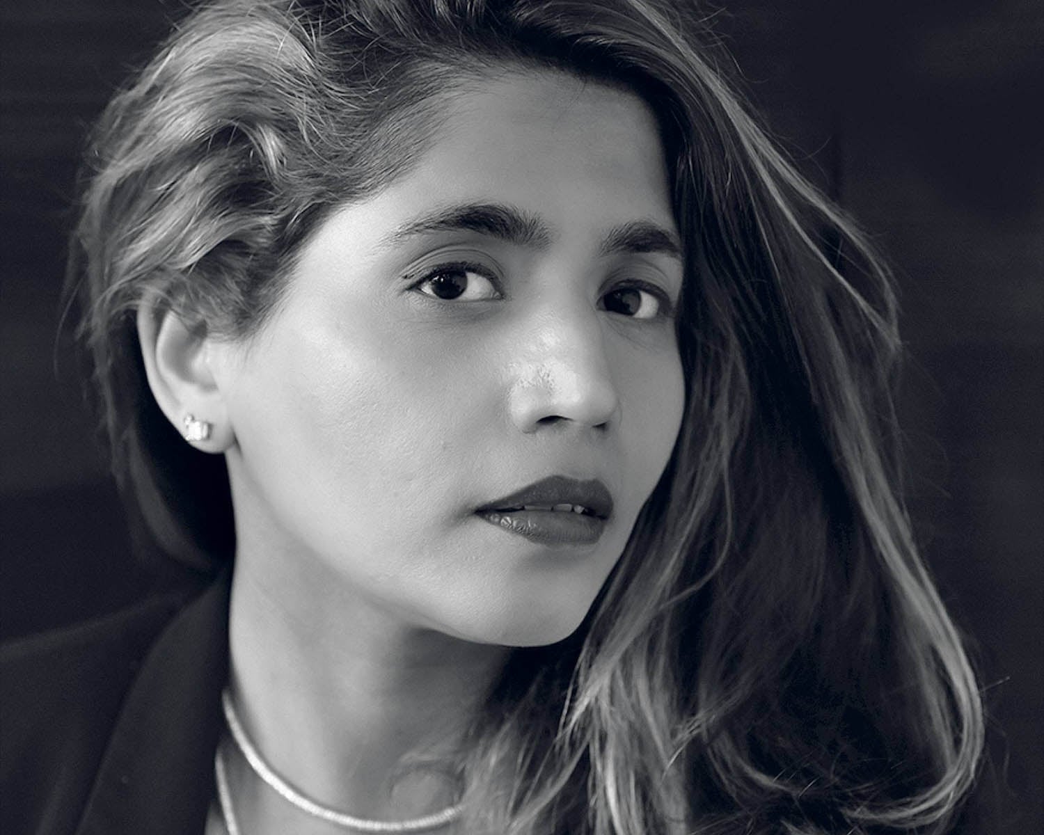 A woman with long hair and a necklace.