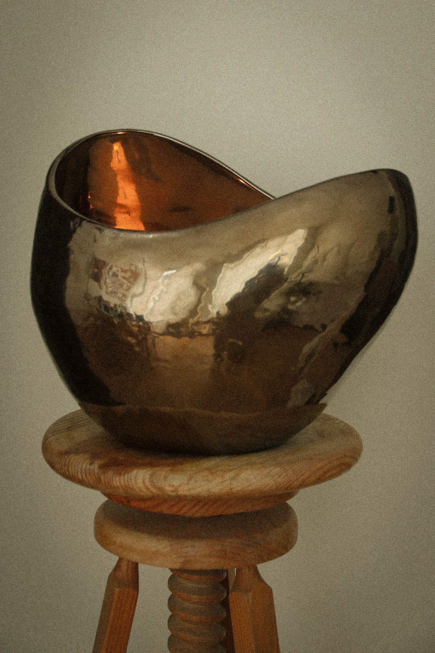 curved tan vase on a stool