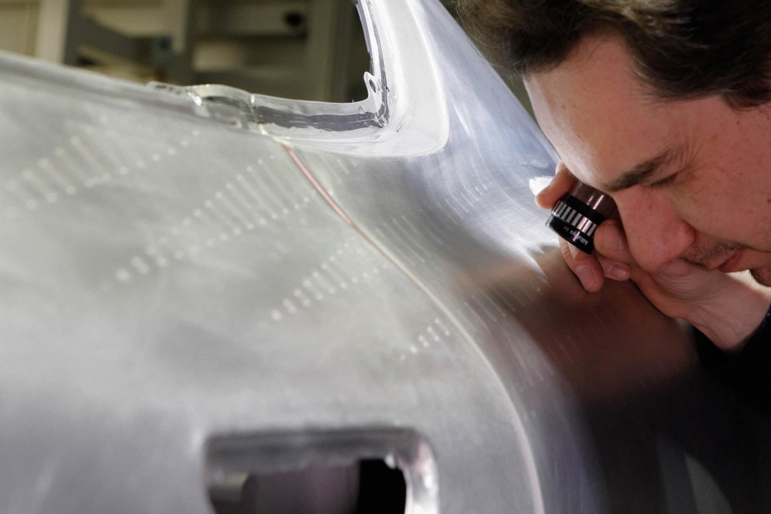 person looking closely at car frame