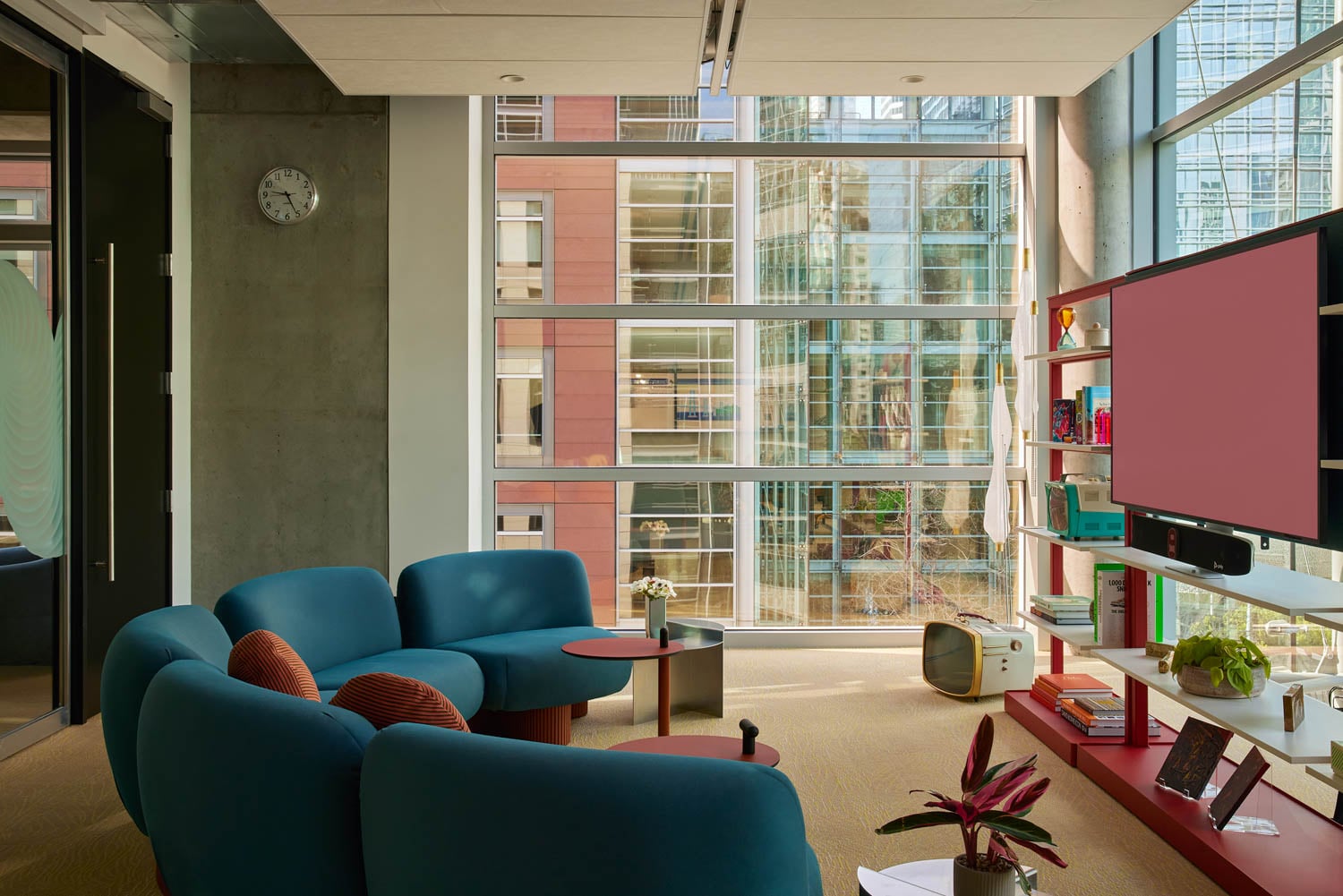 meeting room with blue chairs, red shelf and view of city